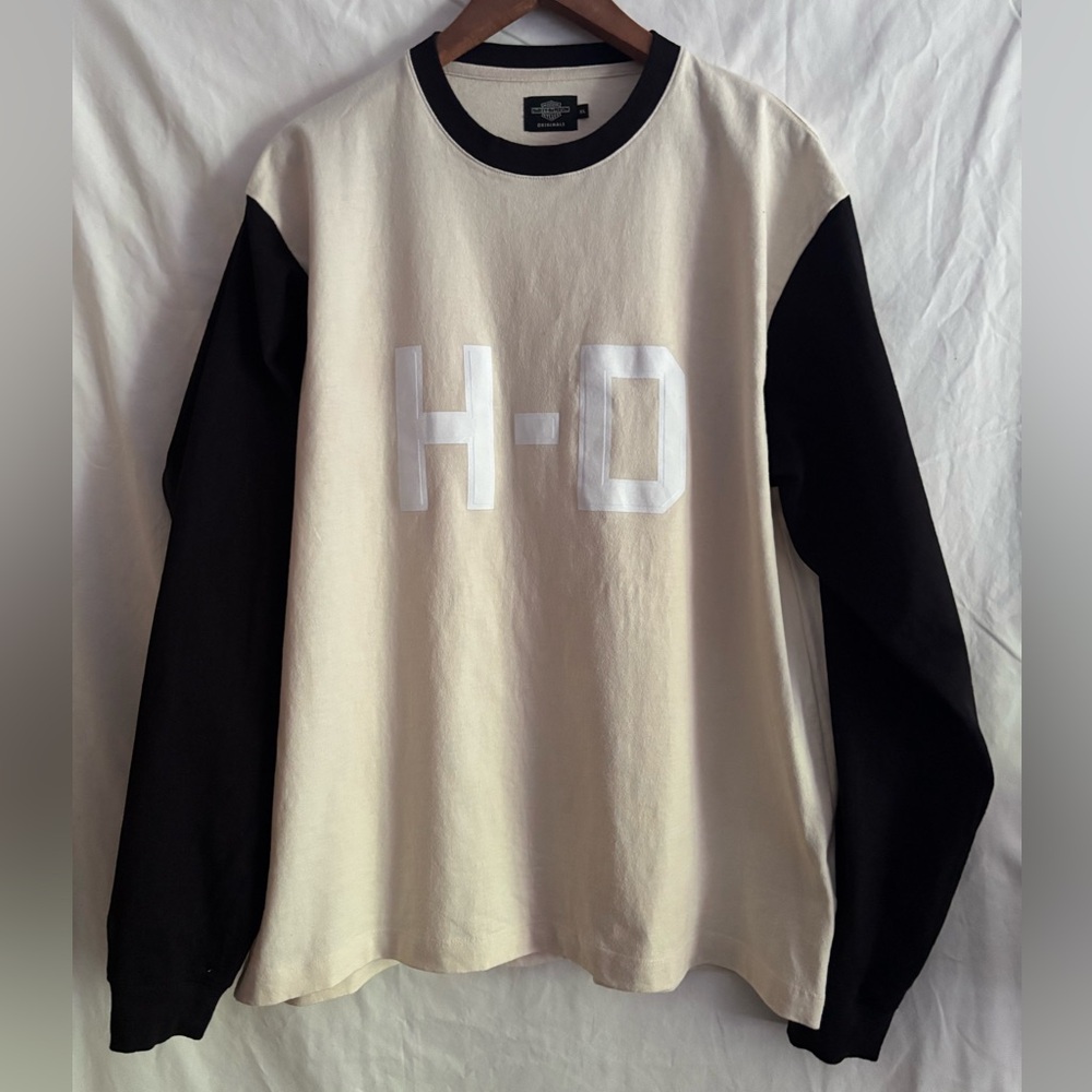 Harley-Davidson cream color body with black long sleeves. H-D lettering front.